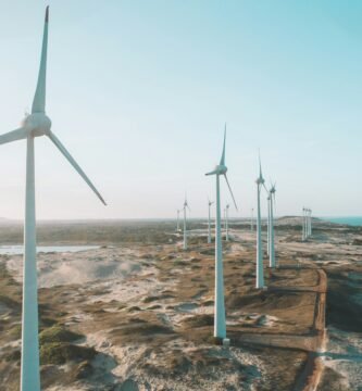 a row of wind turbines next to the ocean